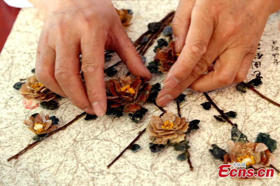 Wang Zhongxiang uses discarded jade fragments to make handicrafts in Qilian County, Northwest China\'s Qinghai Province, March 28, 2019. The 55-year-old folk artist is known for his ability to turn the waste into valuable works of art often through time-consuming processes, such as polishing, painting and pasting. (Photo: China News Service/Ma Mingyan)