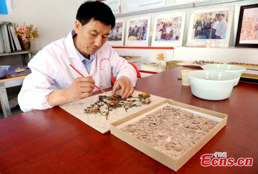 Wang Zhongxiang uses discarded jade fragments to make handicrafts in Qilian County, Northwest China\'s Qinghai Province, March 28, 2019. The 55-year-old folk artist is known for his ability to turn the waste into valuable works of art often through time-consuming processes, such as polishing, painting and pasting. (Photo: China News Service/Ma Mingyan)