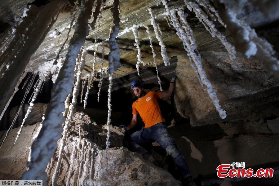 Efraim Cohen, a member of Hebrew University?s Cave Research Center, stands next to salt stalactites inside the Malham Cave, which Israeli researchers say is the world\'s longest salt cave, in Mount Sodom near the Dead Sea, Israel, March 27, 2019. (Photo/Agencies)