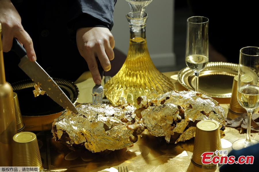 Artist and performer Frederique Lecerf carves a chicken covered with a thin sheet of gold as she prepares her performance meal for guests, a golden dinner with decadent 24 carat gold-covered dishes, in Paris, France, March 28, 2019. (Photo/Agencies)
