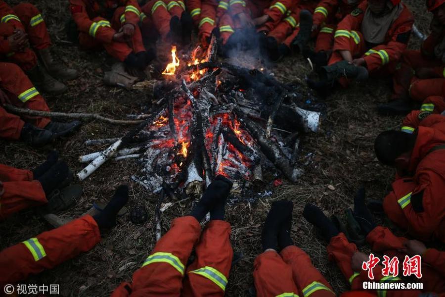 Firefighters took off their cold shoes and warm up in north China\'s Inner Mongolia Autonomous Region on May 20, 2017. (Photo/Agencies)