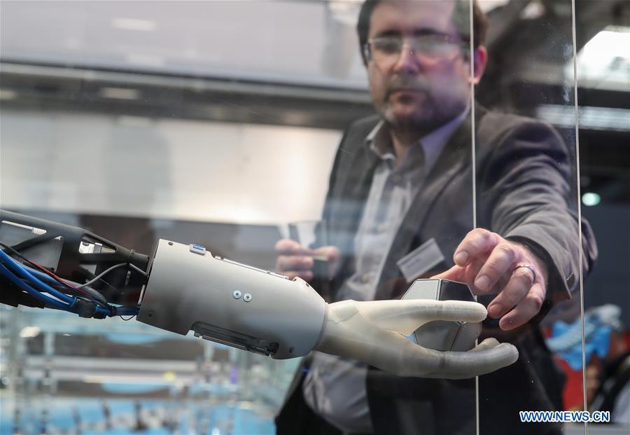A staff member of the booth of Festo demonstrates a bionic robotic arm during the 2019 Hanover Fair in Hanover, Germany, on April 1, 2019. With a total of 6,500 exhibitors from 75 countries and regions, the Hanover Fair shows the latest development of technologies for industrial use, including 5G network, artificial intelligence, light-weight manufacturing among others. (Xinhua/Shan Yuqi)