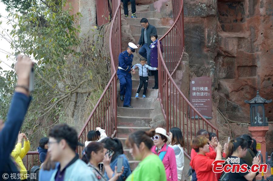 The Jiuqu Zhandao (Nine Bends Plank Road) reopens to tourists at the Leshan Giant Buddha, a UNESCO world heritage site, April 1, 2019. Sixty centimetres at its most narrow and just under one-and-a-half meters at its widest point, the path has 217 steps that wind along a cliff. Standing 71 meters high, the statue was carved out of a hillside in the 8th century and looks down on the confluence of three rivers. (Photo/VCG）