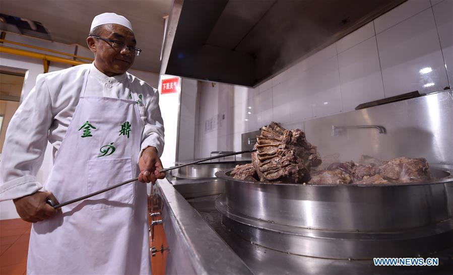 A chef gets noodles from a pot at a beef noodle restaurant in Lanzhou, capital of northwest China\'s Gansu Province, April 2, 2019. Lanzhou beef noodles, a Chinese hand-pulled noodle originated in Lanzhou, has a history of about 100 years. There are about ten types of noodles of different width and shapes, depending on noodle chefs\' pulling skills. It has won fame both at home and abroad with its speciality of noodles and soup recipe. (Xinhua/Fan Peishen)