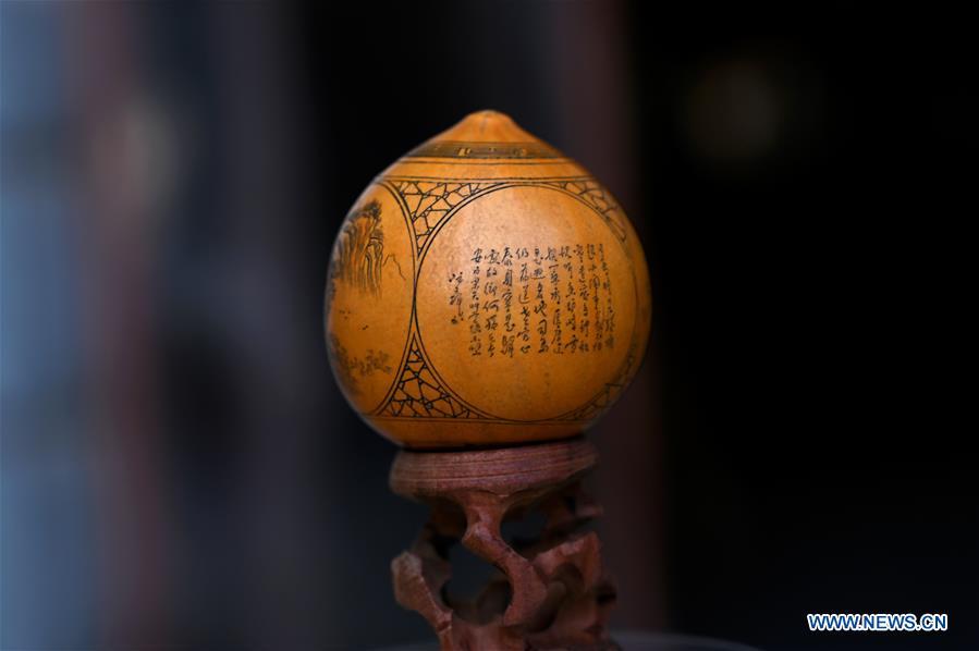 Photo taken on March 31, 2019 shows a carved gourd, created by Ruan Wenhui, a master of Chinese arts and crafts, at a gourd carving studio in Lanzhou, northwest China\'s Gansu Province. A carved gourd, as the name suggests, is a gourd carved with landscapes, portraits, animals, calligraphy or poems, and then painted with ink. The process of gourd carving includes choosing gourd, painting, engraving and coloring. It was insciribed in the first group of provincial intangible cultural heritages of Gansu in 2006. (Xinhua/Liu Jie)