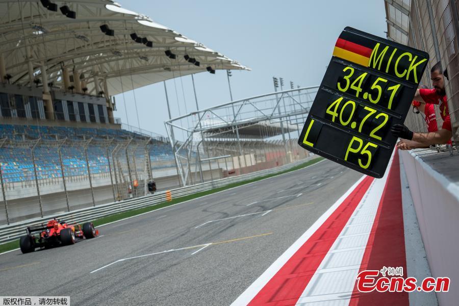 A mechanic of Scuderia Ferrari shows the time board to German Formula 2 driver Mick Schumacher during his first testing for Formula One team Scuderia Ferrari at the Sakhir circuit near Manama, Bahrain,Apr. 2, 2019. (Photo/Agencies)
