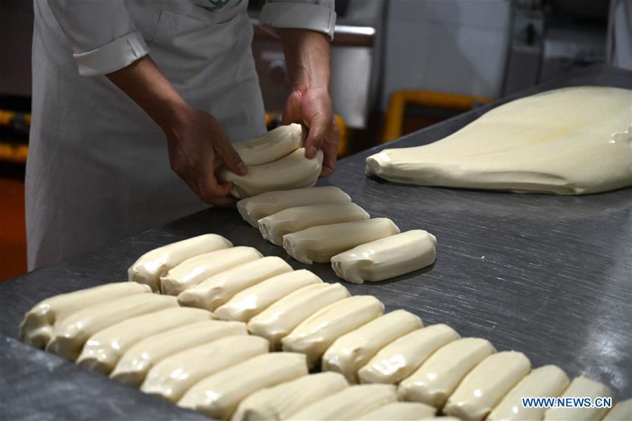 A noodle chef arranges the doughs to be pulled at a beef noodle restaurant in Lanzhou, capital of northwest China\'s Gansu Province, April 2, 2019. Lanzhou beef noodles, a Chinese hand-pulled noodle originated in Lanzhou, has a history of about 100 years. There are about ten types of noodles of different width and shapes, depending on noodle chefs\' pulling skills. It has won fame both at home and abroad with its speciality of noodles and soup recipe. (Xinhua/Liu Jie)