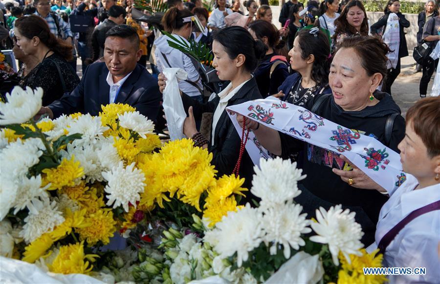 People present hada, a ceremonial silk cloth to show respect, during a spontaneous mourning ceremony to pay tribute to those who lost their lives while fighting the forest fire in a funeral parlour in Xichang City, southwest China\'s Sichuan Province, April 2, 2019. A fire that killed 30 people and engulfed about 15 hectares of forest in southwest China\'s Sichuan Province was extinguished Tuesday, local authorities said. Thirty people, including 27 firefighters and three locals, lost their lives while fighting the fire. (Xinhua/Zhang Chaoqun)