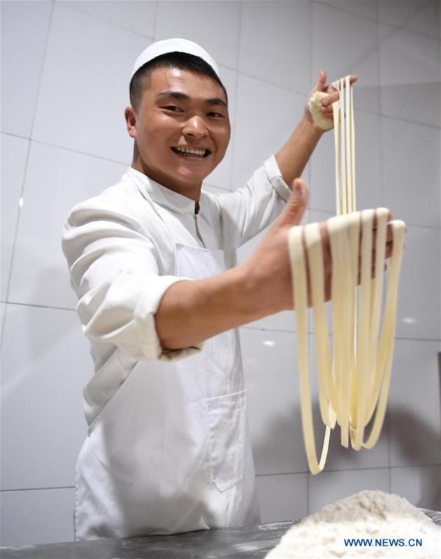 A noodle chef pulls noodles at a beef noodle restaurant in Lanzhou, capital of northwest China\'s Gansu Province, April 2, 2019. Lanzhou beef noodles, a Chinese hand-pulled noodle originated in Lanzhou, has a history of about 100 years. There are about ten types of noodles of different width and shapes, depending on noodle chefs\' pulling skills. It has won fame both at home and abroad with its speciality of noodles and soup recipe. (Xinhua/Fan Peishen)