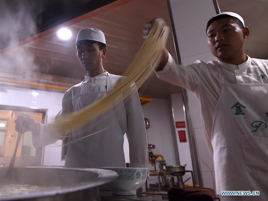 Noodle chefs boil noodles at a beef noodle restaurant in Lanzhou, capital of northwest China\'s Gansu Province, April 2, 2019. Lanzhou beef noodles, a Chinese hand-pulled noodle originated in Lanzhou, has a history of about 100 years. There are about ten types of noodles of different width and shapes, depending on noodle chefs\' pulling skills. It has won fame both at home and abroad with its speciality of noodles and soup recipe. (Xinhua/Fan Peishen)
