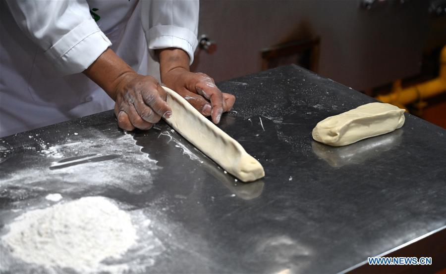 Ma Wenbin, an inheritor of Lanzhou beef noodle, makes noodles at a beef noodle restaurant in Lanzhou, capital of northwest China\'s Gansu Province, April 2, 2019. Lanzhou beef noodles, a Chinese hand-pulled noodle originated in Lanzhou, has a history of about 100 years. There are about ten types of noodles of different width and shapes, depending on noodle chefs\' pulling skills. It has won fame both at home and abroad with its speciality of noodles and soup recipe. (Xinhua/Liu Jie)