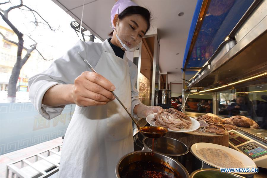 A staff worker prepares cold dishes at a beef noodle restaurant in Lanzhou, capital of northwest China\'s Gansu Province, April 2, 2019. Lanzhou beef noodles, a Chinese hand-pulled noodle originated in Lanzhou, has a history of about 100 years. There are about ten types of noodles of different width and shapes, depending on noodle chefs\' pulling skills. It has won fame both at home and abroad with its speciality of noodles and soup recipe. (Xinhua/Ma Ning)