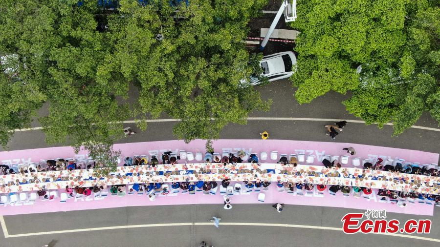 Aerial photo taken on April 3, 2019 shows people eat Luosifen, a local rice noodle dish featuring cooked river snails as ingredient, at a long-table feast in Liuzhou, south China\'s Guangxi Zhuang Autonomous Region. More than 2,000 people joined the feast which was served on tables measuring 1,000 meters in length here on Wednesday.  (Photo/China News Service)