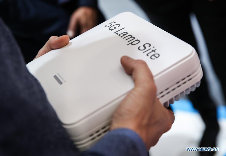 A visitor holds a Huawei 5G Lamp Site at the booth of Huawei during the 2019 Hanover Fair in Hanover, Germany, April 3, 2019. (Xinhua/Shan Yuqi)