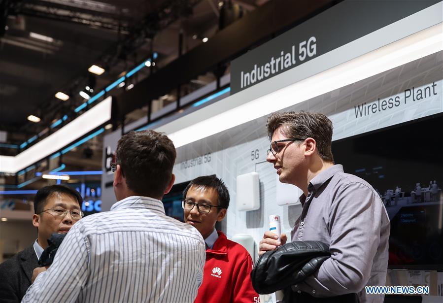 A staff member (L) introduces a Huawei product as a visitor looks on at the booth of Huawei during the 2019 Hanover Fair in Hanover, Germany, April 3, 2019. (Xinhua/Shan Yuqi)