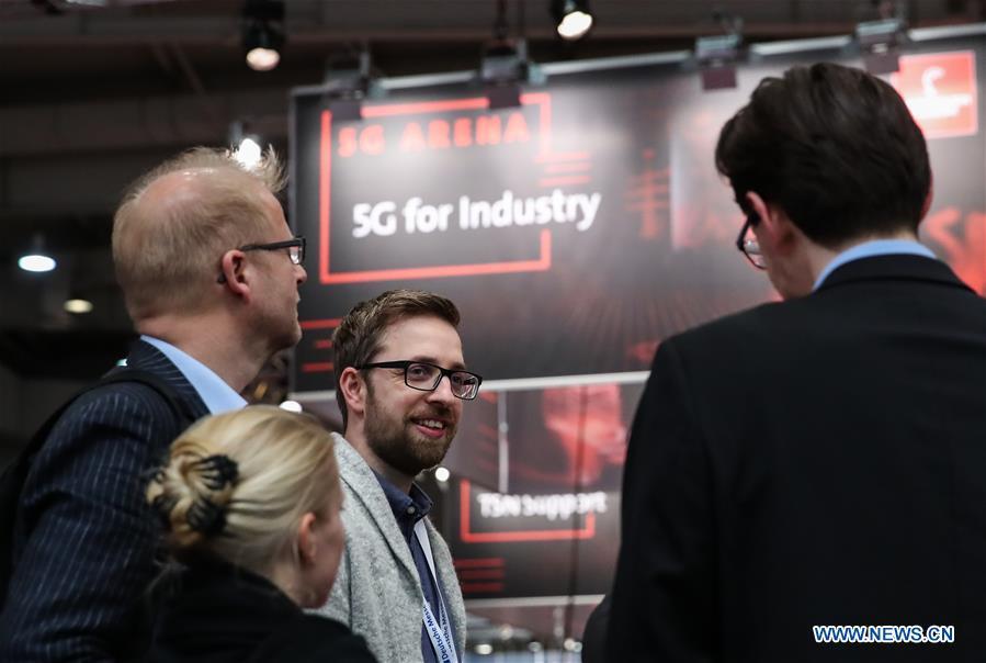 Visitors talk with a staff member at the 5G Arena during the 2019 Hanover Fair in Hanover, Germany, April 1, 2019. (Xinhua/Shan Yuqi)
