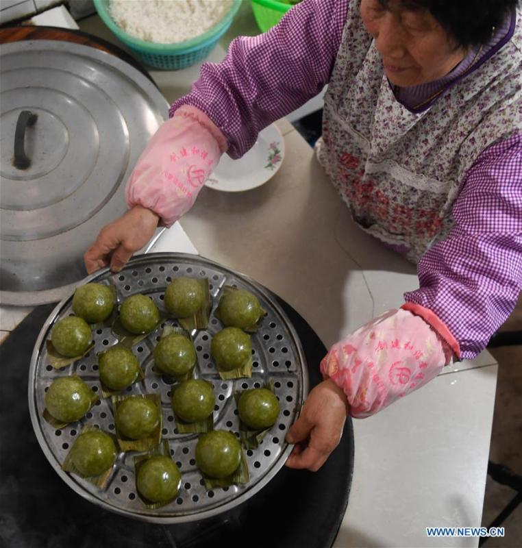 A villager shows steamed Qingtuan, or green sticky rice balls, in Yiyanshan Village of Huzhou, east China\'s Zhejiang Province, April 4, 2019. Qingtuan, made from glutinous rice mixed with wormwood juice and stuffed with bamboo shoot, tofu and preserved meat, is a traditional snack popular mailnly among people living in the south of Yangtze River during the Qingming Festival also known as Tomb Sweeping Day. (Xinhua/Huang Zongzhi)