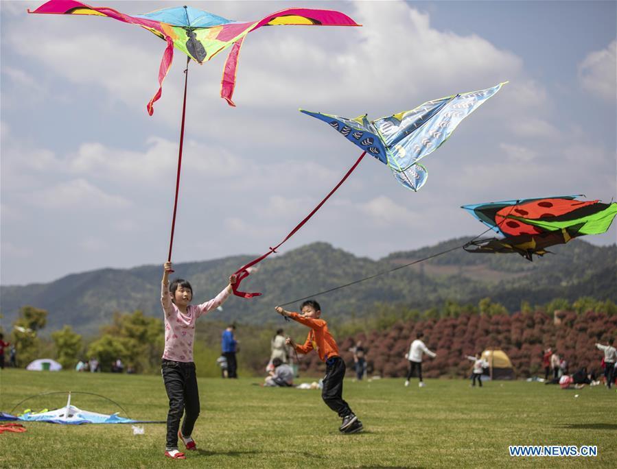 Children fly kites during the holiday for the Qingming Festival at Xiannyuhu scenic spot in Xinyu, east China\'s Jiangxi Province, April 5, 2019, (Xinhua/Zhao Chunliang)
