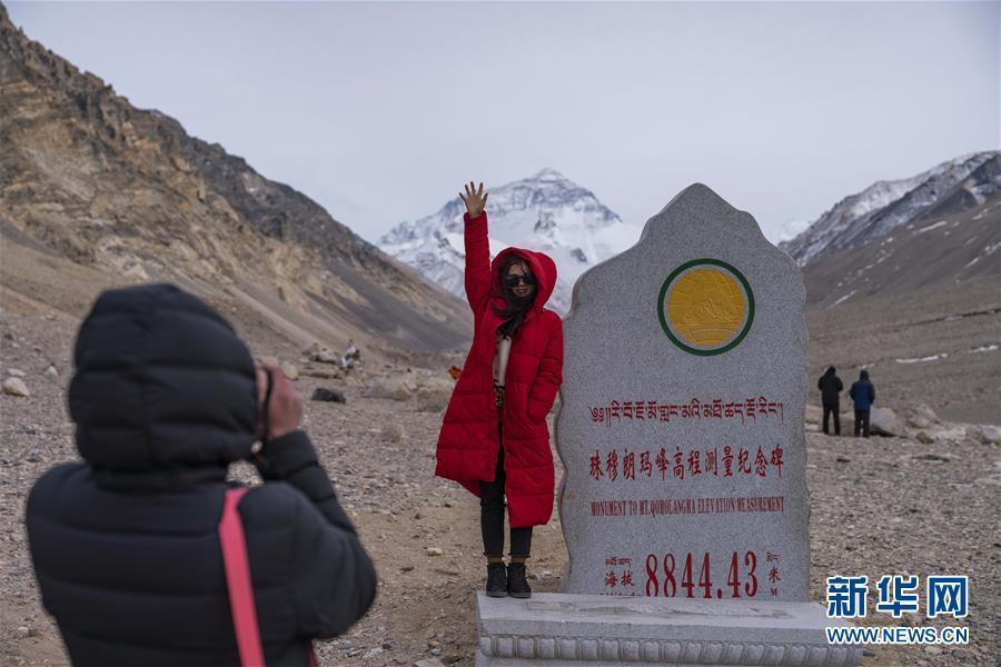 A tourist poses for a photo at the foot of the Mount Qomolangma in Southwest China’s Tibet Autonomous Region, April 6, 2019.(Photo/Xinhua)