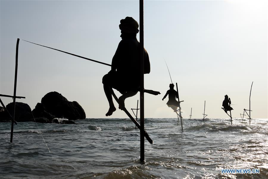 Stilt fishermen are silhouetted at a beach in Galle, Sri Lanka, April 7, 2019. Stilt fishing is a method of fishing unique to the island country of Sri Lanka. Local fishermen sit on a crossbar called \