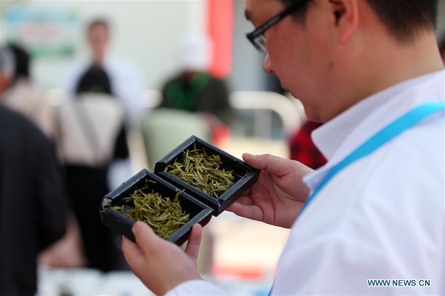 An expert examines used tea leaves during a tea competition in Huangshan, a famous tea producing area in east China\'s Anhui Province, April 7, 2019. Local tea farmers bring a total of 60 varieties of tea leaves to take part in the competition here on Sunday. (Xinhua/Shi Yalei)
