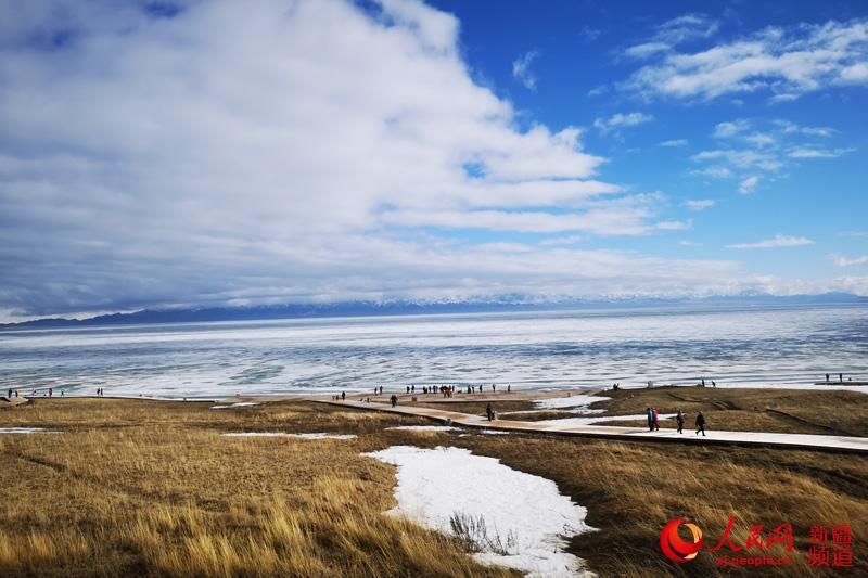 Photo shows thawing ice on the surface of Sayram Lake in northwest China\'s Xinjiang Uyghur Autonomous Region. The swans, the high mountains, the clear water and the blue sky have turned the lake into a spring fairyland.  (Photo/people.cn)