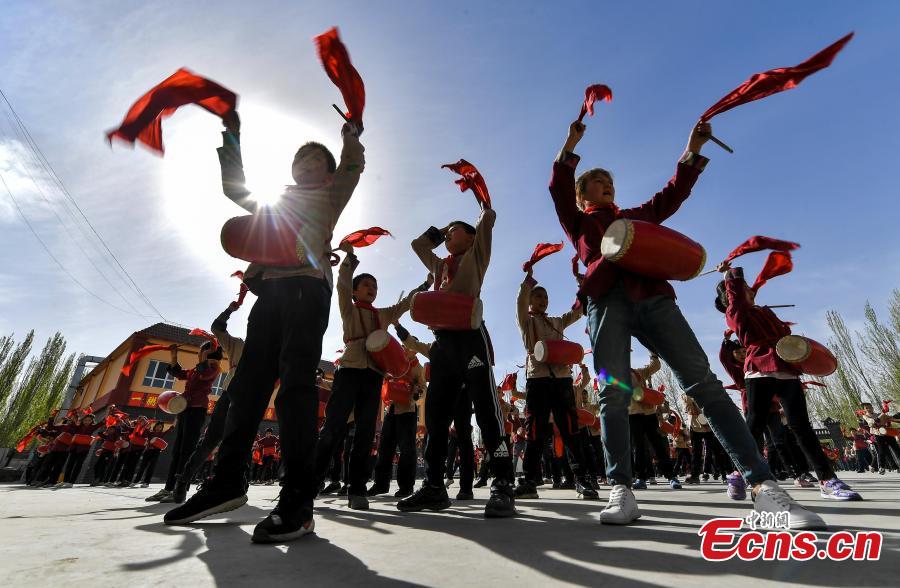 Photo shows students from a primary school in Wushi County, in northwest China\'s Xinjiang Uygur Autonomous Region learning waist drum, April 8, 2019. (Photo/China News Service)