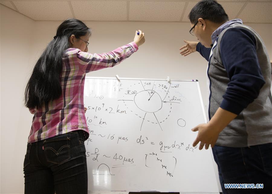 Chinese researchers discuss the imaging methods of the image of a black hole in Shanghai Astronomical Observatory (SAO), in east China\'s Shanghai, April 9, 2019. The image of the black hole, based on observations through the Event Horizon Telescope (EHT), a planet-scale array of eight ground-based radio telescopes forged through international collaboration, was unveiled in coordinated press conferences across the globe at around 9:00 p.m. (Beijing time) on Wednesday. The landmark result offers scientists a new way to study the most extreme objects in the universe predicted by Albert Einstein\'s general relativity. (Xinhua/Jin Liwang)