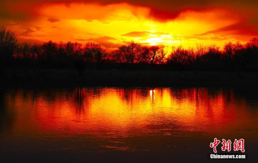 The sunset\'s glow bathes the Irtysh River in Northwest China\'s Xinjiang Uygur Autonomous Region. Beginning in the Altay Mountains in Xinjiang, the 4,248-kilometer-long Irtysh River is the only river in China to flow into the Arctic Ocean. (Photo: China News Service/Xie Shimin)