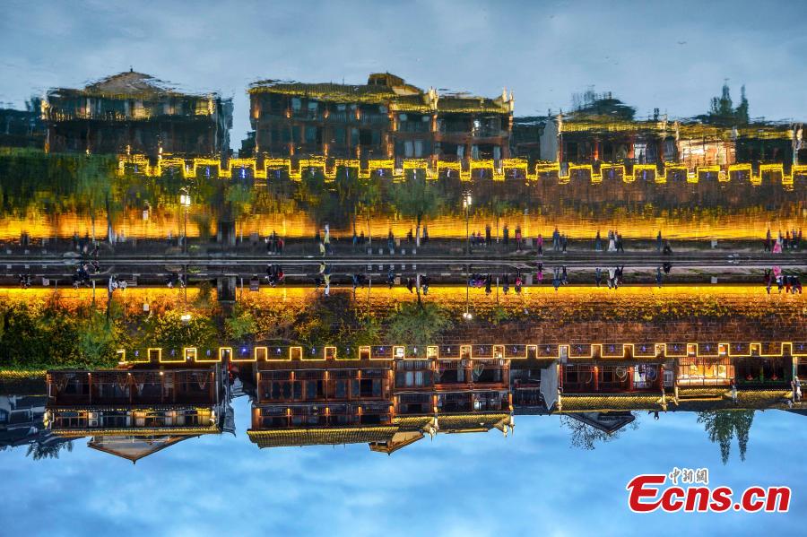 Illuminated buildings are reflected in the Tuojiang River in Fenghuang Ancient Town, Hunan Province, April 11, 2019. The old town is famous for its time-honored buildings and cultural relics, attracting large numbers of visitors each year from China and abroad. (Photo: China News Service/Yang Huafeng)