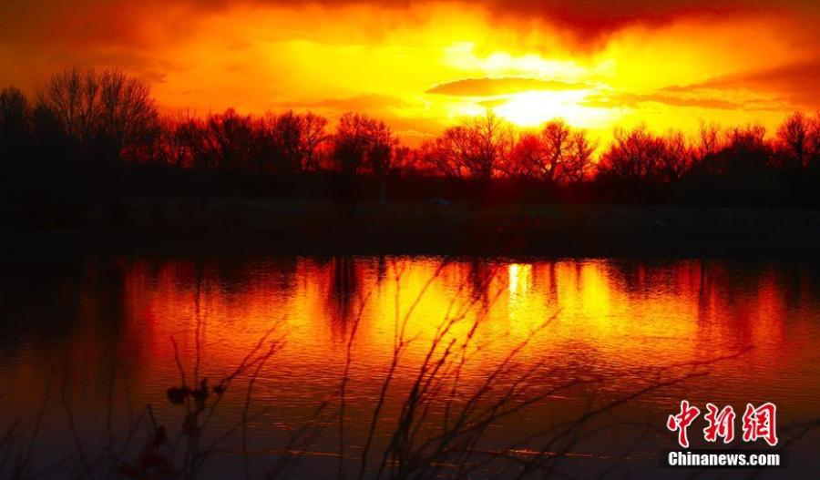 The sunset\'s glow bathes the Irtysh River in Northwest China\'s Xinjiang Uygur Autonomous Region. Beginning in the Altay Mountains in Xinjiang, the 4,248-kilometer-long Irtysh River is the only river in China to flow into the Arctic Ocean. (Photo: China News Service/Xie Shimin)
