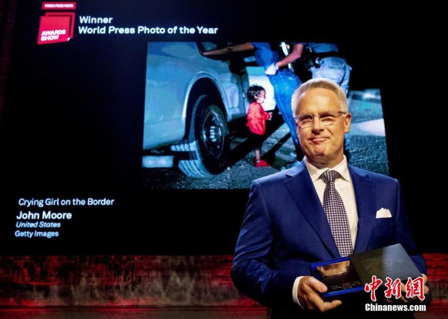 John Moore stands in front of his award-winning photo, which shows a two-year-old Honduran asylum seeker cries as her mother is searched and detained near the US-Mexico border, during the World Press Photo Awards Show 2019. (Photo/Agencies)

The annual photo contest rewards photographers for the best single exposure pictures contributing to the past year of visual journalism. Whether entered as singles or stories, these pictures are judged in terms of their accurate, fair, and visually compelling insights about our world.