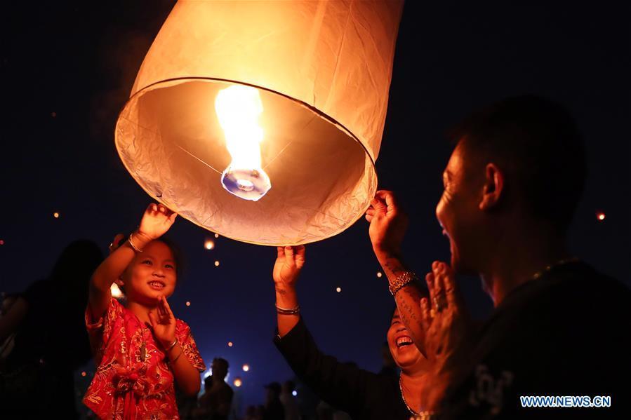 People fly Kongming lanterns, a kind of small hot-air paper balloon, by the Lancang River in Jinghong City, southwest China\'s Yunnan Province, April 13, 2019, to celebrate the New Year of the calendar of the Dai ethnic group. (Xinhua/Zhang Yuwei)