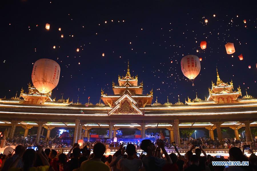 People fly Kongming lanterns, a kind of small hot-air paper balloon, by the Lancang River in Jinghong City, southwest China\'s Yunnan Province, April 13, 2019, to celebrate the New Year of the calendar of the Dai ethnic group. (Xinhua/Qin Qing)