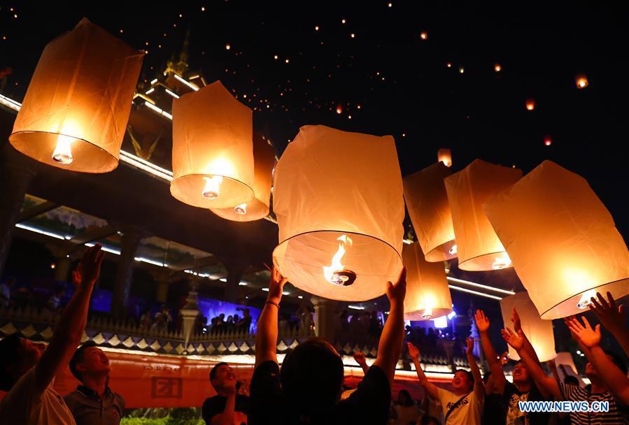 People fly Kongming lanterns, a kind of small hot-air paper balloon, by the Lancang River in Jinghong City, southwest China\'s Yunnan Province, April 13, 2019, to celebrate the New Year of the calendar of the Dai ethnic group. (Xinhua/Zhang Yuwei)