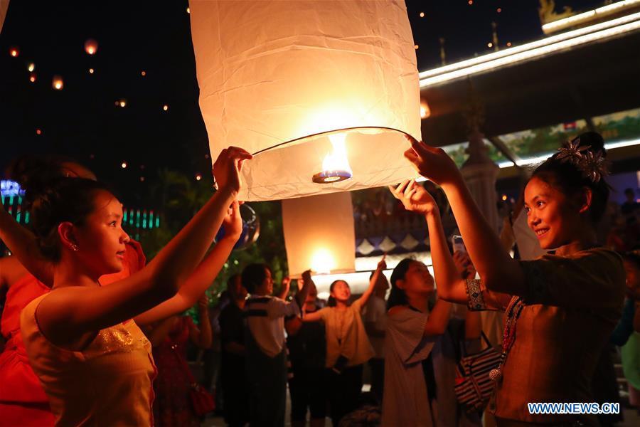 People fly Kongming lanterns, a kind of small hot-air paper balloon, by the Lancang River in Jinghong City, southwest China\'s Yunnan Province, April 13, 2019, to celebrate the New Year of the calendar of the Dai ethnic group. (Xinhua/Zhang Yuwei)