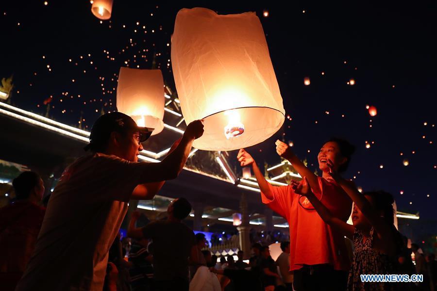 People fly Kongming lanterns, a kind of small hot-air paper balloon, by the Lancang River in Jinghong City, southwest China\'s Yunnan Province, April 13, 2019, to celebrate the New Year of the calendar of the Dai ethnic group. (Xinhua/Zhang Yuwei)