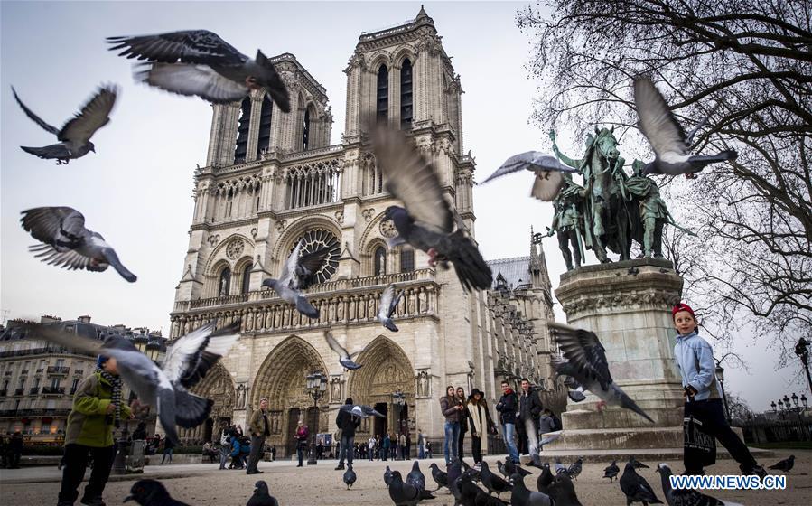 In this file photo taken on March 13, 2015, tourists visit the Notre Dame Cathedral in Paris, France. The devastating fire at Notre Dame Cathedral in central Paris has been put out after burning for 15 hours, local media reported on April 16, 2019. In early evening on April 15, a fire broke out in the famed cathedral. Online footage showed thick smoke billowing from the top of the cathedral and huge flames between its two bell towers engulfing the spire and the entire roof which both collapsed later. Notre Dame is considered one of the finest examples of French Gothic architecture which receives about 12 million visitors every year. (Xinhua/Chen Xiaowei)