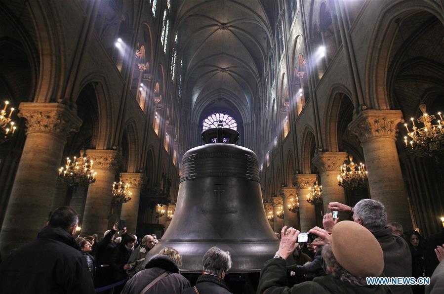 In this file photo taken on Feb. 15, 2013, visitors look at a new bronze bell made to celebrate the 850th anniversary of the Notre Dame Cathedral in Paris, France. The devastating fire at Notre Dame Cathedral in central Paris has been put out after burning for 15 hours, local media reported on April 16, 2019. In early evening on April 15, a fire broke out in the famed cathedral. Online footage showed thick smoke billowing from the top of the cathedral and huge flames between its two bell towers engulfing the spire and the entire roof which both collapsed later. Notre Dame is considered one of the finest examples of French Gothic architecture which receives about 12 million visitors every year. (Xinhua/Gao Jing)