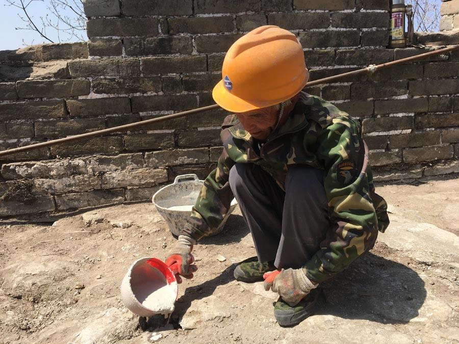 A worker fills cracks on the wall using material made from lime and sticky rice. (PHOTO/CHINA DAILY)

\