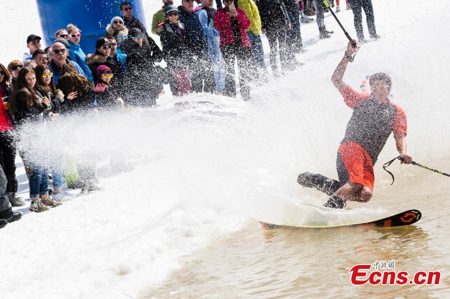 A skier participates in a waterslide contest as part of the closing event of the \