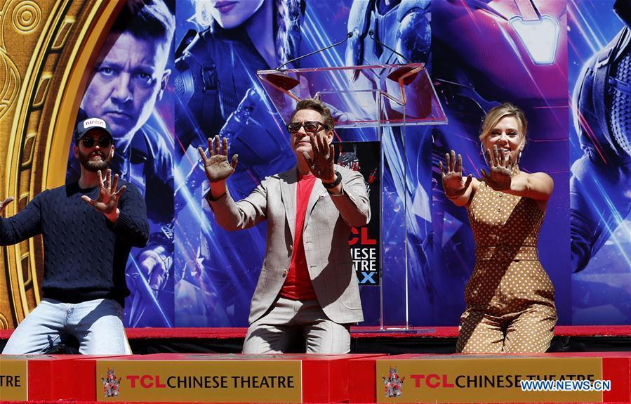 Actor Robert Downey Jr. (C) , Chris Evans (L) and actress Scarlett Johansson show their hands after putting their handprints in cement during print ceremony in the forecourt of the TCL Chinese Theater in Los Angeles, the United States, April 23, 2019. The cast of Marvel Studios \