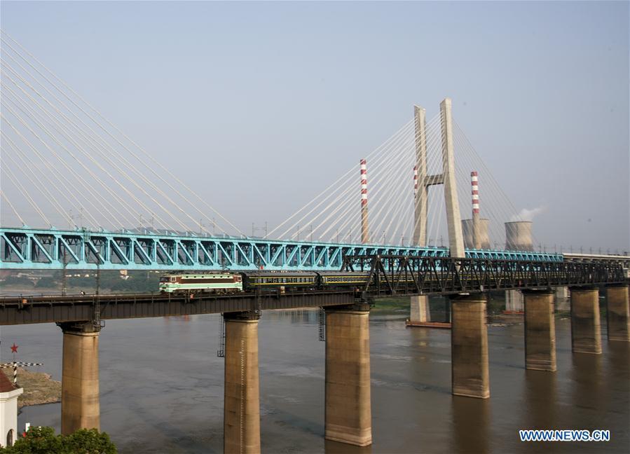 The last train runs on the previous Baishatuo Yangtze River railway bridge in Jiangjin of southwest China\'s Chongqing Municipality, April 23, 2019. The previous Baishatuo Yangtze River railway bridge, completed in 1959, will stop service after April 24. All trains will run on the new double decker steel truss cable stay railway bridge after that day. The new bridge has 4 tracks on the upper deck for passenger trains with a designed speed of 200 kilometers per hour and 2 tracks on the lower deck for cargo trains with the designed speed of 120 kilometers per hour. (Xinhua/Liu Chan)