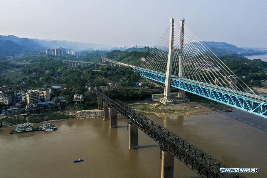Aerial photo taken on April 23, 2019 shows the previous (L) and the new Baishatuo Yangtze River railway bridge in Jiangjin of southwest China\'s Chongqing Municipality. The previous Baishatuo Yangtze River railway bridge, completed in 1959, will stop service after April 24. All trains will run on the new double decker steel truss cable stay railway bridge after that day. The new bridge has 4 tracks on the upper deck for passenger trains with a designed speed of 200 kilometers per hour and 2 tracks on the lower deck for cargo trains with the designed speed of 120 kilometers per hour. (Xinhua/Liu Chan)