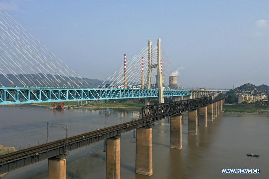 Aerial photo taken on April 23, 2019 shows the previous (R) and the new Baishatuo Yangtze River railway bridge in Jiangjin of southwest China\'s Chongqing Municipality. The previous Baishatuo Yangtze River railway bridge, completed in 1959, will stop service after April 24. All trains will run on the new double decker steel truss cable stay railway bridge after that day. The new bridge has 4 tracks on the upper deck for passenger trains with a designed speed of 200 kilometers per hour and 2 tracks on the lower deck for cargo trains with the designed speed of 120 kilometers per hour. (Xinhua/Liu Chan)