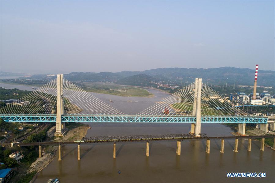 Aerial photo shows the last train running on the previous Baishatuo Yangtze River railway bridge (Front) in Jiangjin of southwest China\'s Chongqing Municipality, on April 23, 2019. The previous Baishatuo Yangtze River railway bridge, completed in 1959, will stop service after April 24. All trains will run on the new double decker steel truss cable stay railway bridge after that day. The new bridge has 4 tracks on the upper deck for passenger trains with a designed speed of 200 kilometers per hour and 2 tracks on the lower deck for cargo trains with the designed speed of 120 kilometers per hour. (Xinhua/Liu Chan)