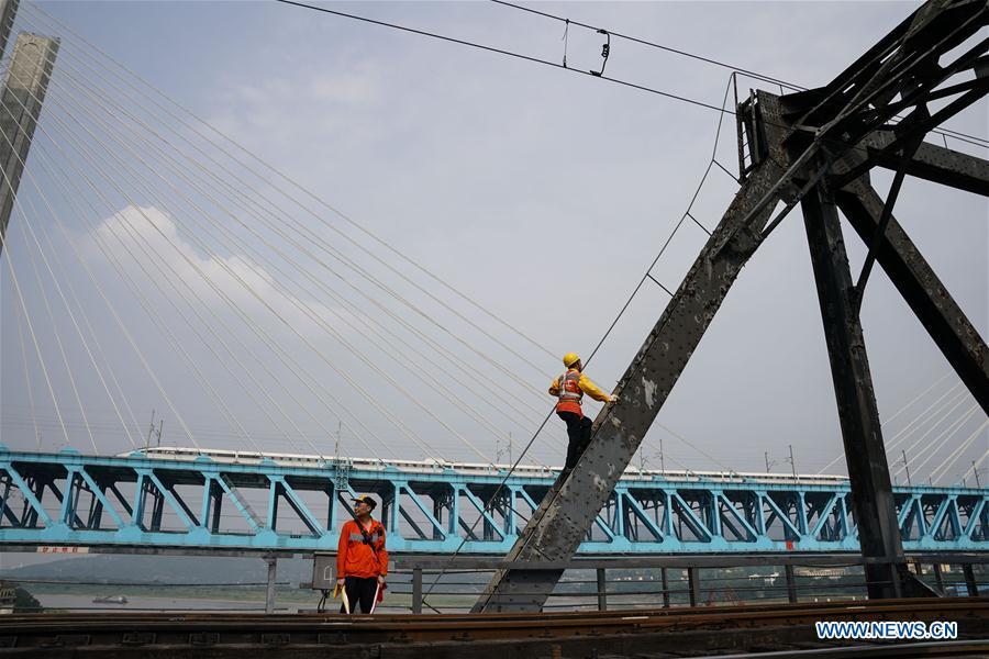 Workers of China Railway Chengdu Group Co., Ltd. conduct final check on the previous Baishatuo Yangtze River railway bridge in Jiangjin of southwest China\'s Chongqing Municipality, April 23, 2019. The previous Baishatuo Yangtze River railway bridge, completed in 1959, will stop service after April 24. All trains will run on the new double decker steel truss cable stay railway bridge after that day. The new bridge has 4 tracks on the upper deck for passenger trains with a designed speed of 200 kilometers per hour and 2 tracks on the lower deck for cargo trains with the designed speed of 120 kilometers per hour. (Xinhua/Liu Chan)