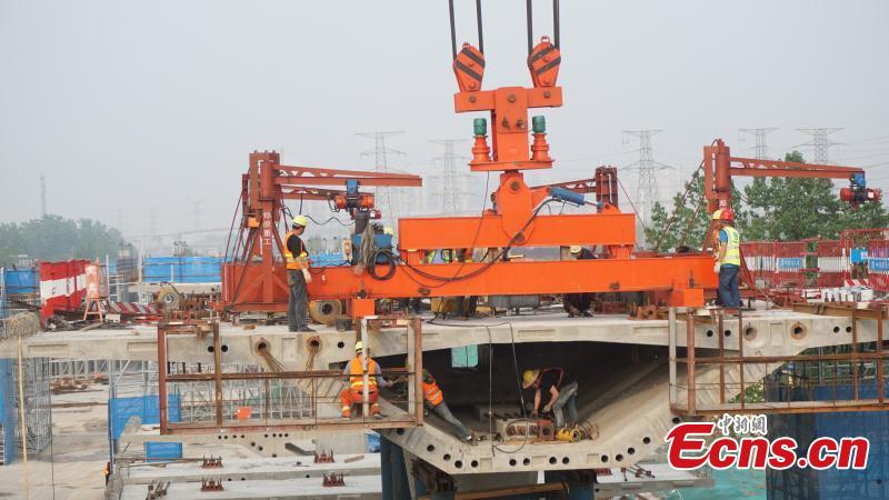 Construction workers build a new elevated road in Zhengzhou City, Central China\'s Henan Province. An innovative technology using prefabricated materials has ensured faster construction that is also energy-saving and environmentally friendly. (Photo: China News Service/Yang Lei)