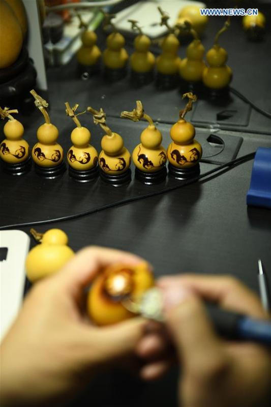 Craftsman Liu Chunpu creates cucurbit pyrography at a studio in Yuhua District of Shijiazhuang, north China\'s Hebei Province, April 23, 2019. Liu Chunpu, a staff member of Hebei Normal University, has devoted himself in cucurbit pyrography for more than 40 years. (Xinhua/Xu Jianyuan)