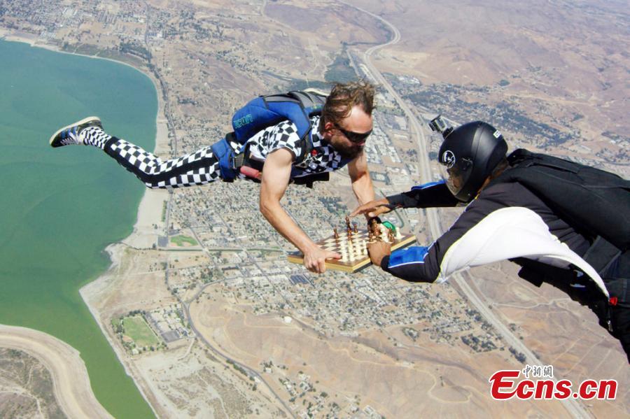 Timur Faridovich Gareyev is pictured skydiving while holding a chess board. 31-year-old Timur is a chess player from Tashkent, Uzbekistan. He is also an experienced skydiver with 150 jumps under his belt. He jumped from the aircraft wearing a chequered jumpsuit with the chess pieces fixed onto the board on his way to contest a San Diego Chess Open in California. (Photo/IC)